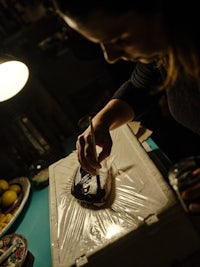 a woman is working on a piece of paper in a dark room