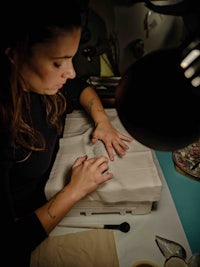 a woman is working on a piece of paper in a dark room